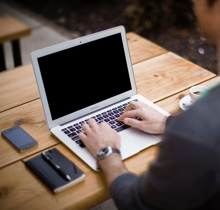 Männliche Hände auf Laptop-Tastatur