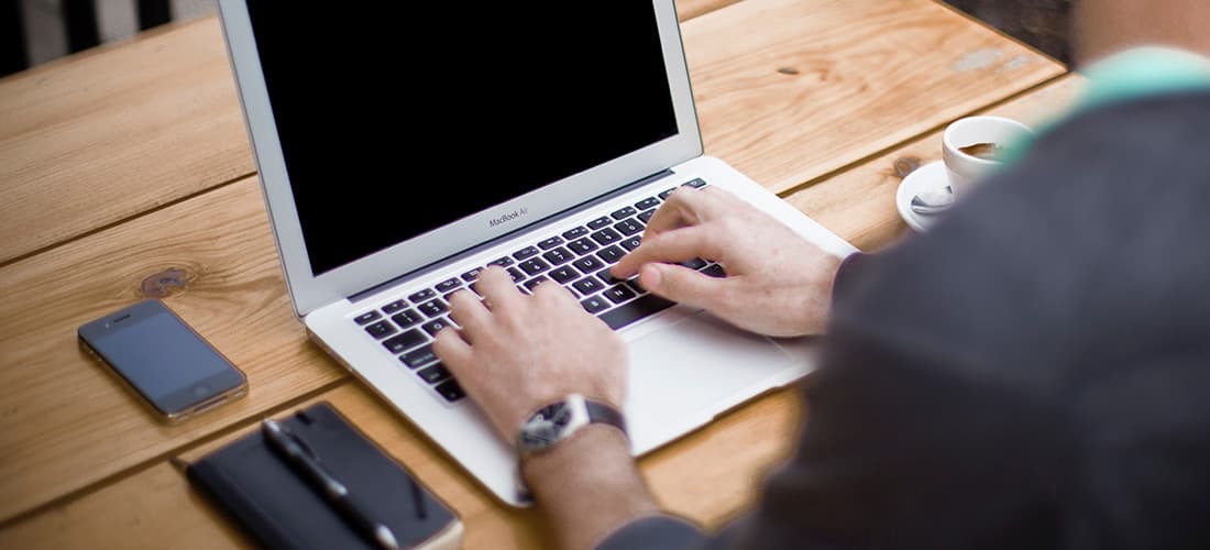 Männliche Hände auf Laptop-Tastatur