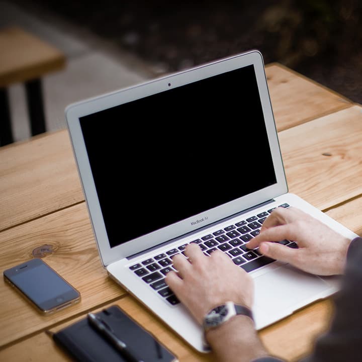 Männliche Hände auf Laptop-Tastatur