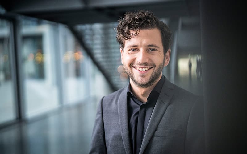 Felix Banaszak im Foyer des Bundestages mit Treppe im Hintergrund