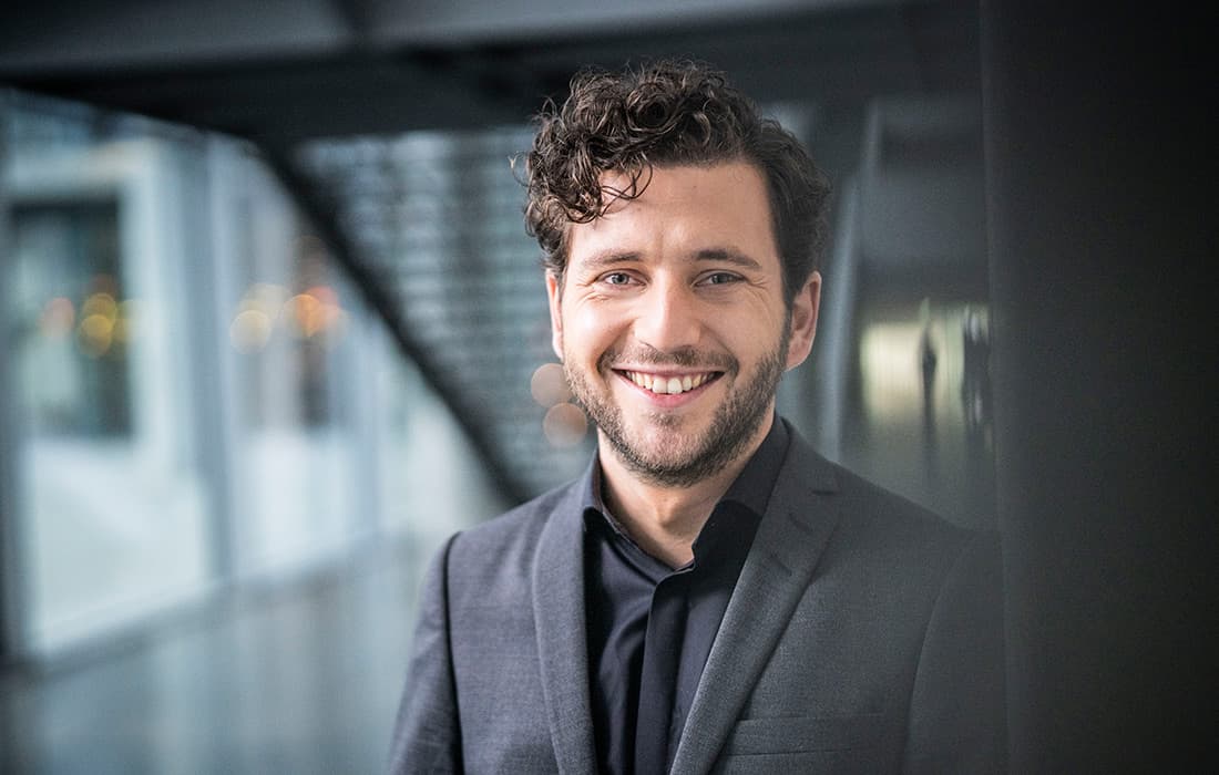 Felix Banaszak im Foyer des Bundestages mit Treppe im Hintergrund