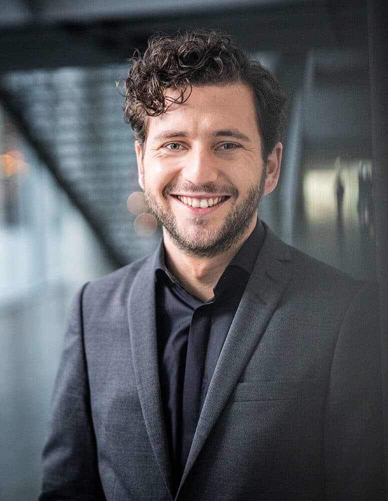 Felix Banaszak im Foyer des Bundestages mit Treppe im Hintergrund